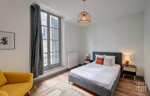 een slaapkamer met een bed, een bank en een raam bij Le Racine / Colbert - Bords De Loire in Tours