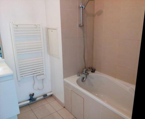 ein Badezimmer mit einer Badewanne und einem Waschbecken in der Unterkunft Les Villas Terrasses (close Stade de France) idéal JO in Saint-Denis