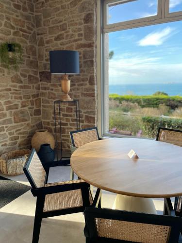 une salle à manger avec une table et des chaises et une fenêtre dans l'établissement Hôtel Les Costans, The Originals Relais, à Perros-Guirec