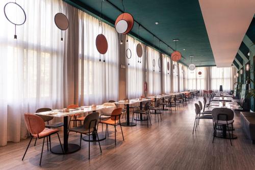 una fila di tavoli e sedie in un ristorante di Quark Hotel Milano a Milano