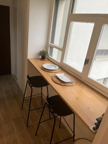 a table in a room with two chairs and a window at Charmant studio in Franconville