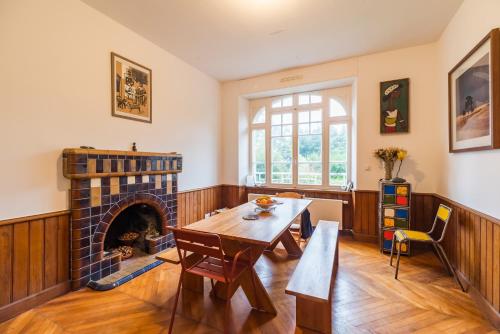 un salon avec une table et une cheminée dans l'établissement La Villa des Troënes - Proche des plages, à Plouguiel