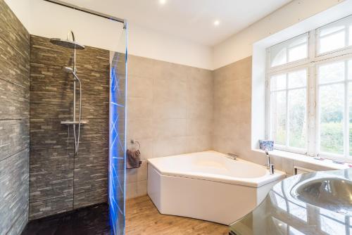 une salle de bain avec une baignoire, une douche et un lavabo dans l'établissement La Villa des Troënes - Proche des plages, à Plouguiel