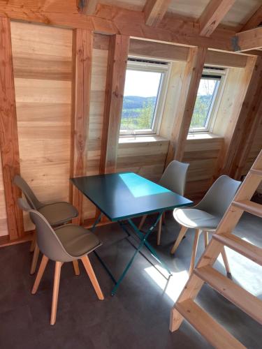 ein Esszimmer mit einem Tisch und Stühlen in einer Hütte in der Unterkunft Grangette au chateau de Castelnau in Prudhomat