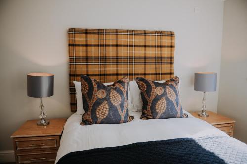 a bedroom with a bed with pillows and two lamps at Pattys Barn Holiday Cottages, Cabins and Venue Hire in Cockerham