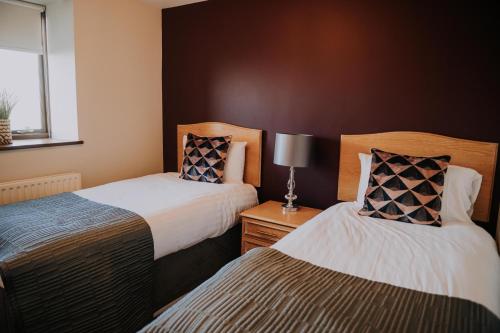 a bedroom with two beds and a window at Pattys Barn Holiday Cottages, Cabins and Venue Hire in Cockerham