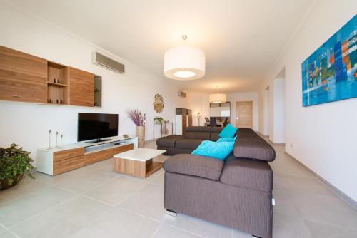 a living room with a couch and a tv at Seafront Apartment Sliema in Sliema