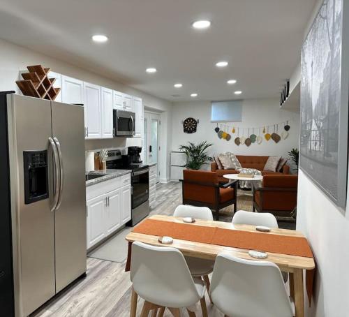a kitchen and living room with a table and a refrigerator at Garden's Grace: Whispers in Silver Spring