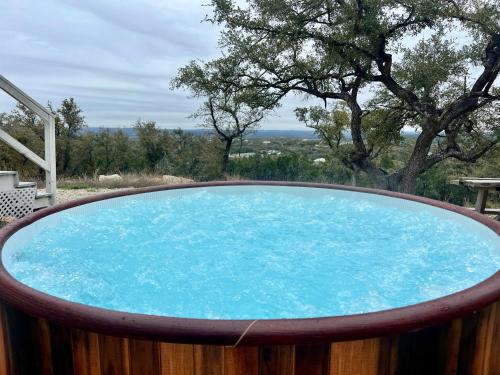 a hot tub with a view of a tree at The Perch- Texas Tiny Haus with amazing views in Spring Branch
