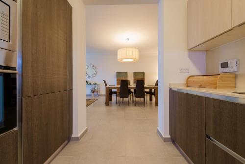 a kitchen and dining room with a table and chairs at Seafront Apartment Sliema in Sliema