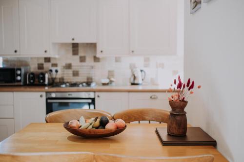 a kitchen with a wooden table with a bowl of fruit at Pattys Barn Holiday Cottages, Cabins and Venue Hire in Cockerham