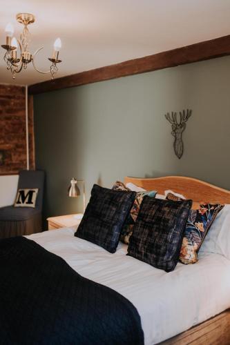 a bed with black and white pillows on it at Pattys Barn Holiday Cottages, Cabins and Venue Hire in Cockerham