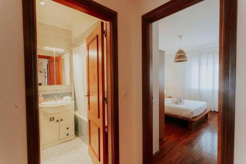 een badkamer met een bed, een wastafel en een spiegel bij Best Houses 68 - Downtown Ferrel in Ferrel