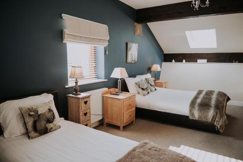 a bedroom with two beds and a window at Pattys Barn Holiday Cottages, Cabins and Venue Hire in Cockerham