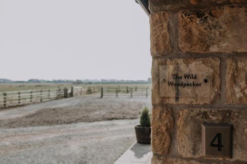 a brick wall with a sign that reads the wild werewolf at Pattys Barn Holiday Cottages, Cabins and Venue Hire in Cockerham