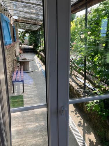 a window view of a patio with a table and a bench at Chambre d'Hôtes chez Gustave & Compagnie in Choussy