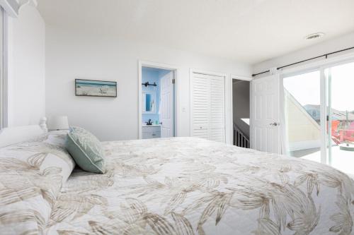 a white bedroom with a large bed and a window at Oceanside Cottage -3BDR 2BA-Walk to Beach! in Kill Devil Hills