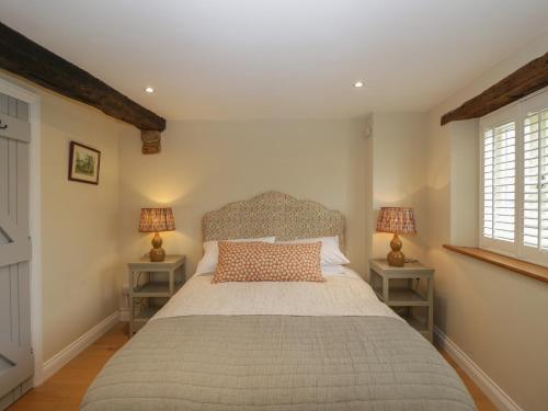 1 dormitorio con 1 cama grande y 2 mesitas de noche en Kyte Cottage en Shipston on Stour