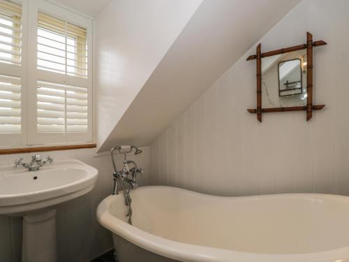 uma casa de banho branca com um lavatório e uma banheira em Kyte Cottage em Shipston on Stour