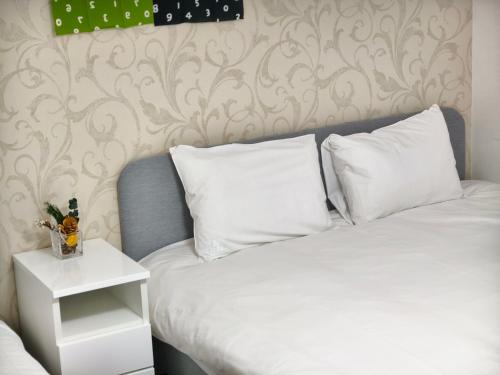 a bedroom with a bed with white pillows and a table at Rest collection Fushimi-Inari Kyoto in Kyoto
