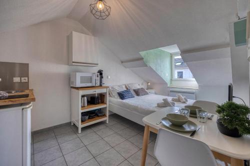 une chambre avec un lit et une table et une cuisine dans l'établissement L'Ecrin d'Alembert - Clinique Mutualiste / Rocade, à Grenoble