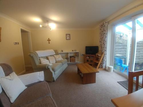 a living room with a couch and a tv at Ty Newydd Gwyn - G/F Room in Denbigh