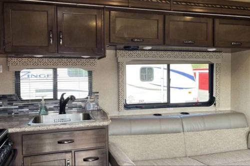 una cocina con fregadero y 2 ventanas en 32 ft Motorhome Sleeps 10 en Springfield