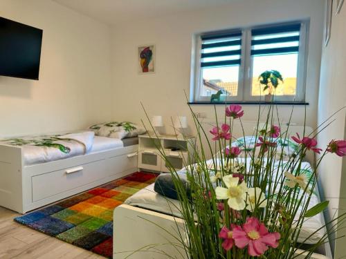 Habitación con cama y sofá con flores en Ferienwohnungen GoJa, en Bad Königshofen im Grabfeld
