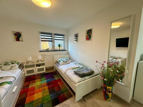 1 dormitorio con 2 camas y alfombra colorida en Ferienwohnungen GoJa, en Bad Königshofen im Grabfeld