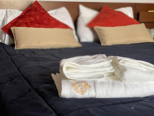 un letto con asciugamani e cuscini bianchi di Skyscraper Apartment Pontedera a Pontedera