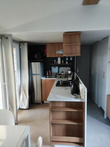une cuisine avec une cuisinière et un réfrigérateur dans l'établissement Mobil-home dans camping 4 étoiles 6 à 8 personnes 40m2, à Lège-Cap-Ferret