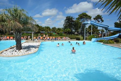 un groupe de personnes dans une piscine d'un complexe hôtelier dans l'établissement Mobil-home dans camping 4 étoiles 6 à 8 personnes 40m2, à Lège-Cap-Ferret