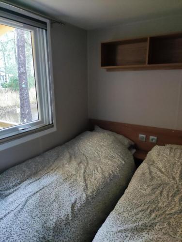 - une chambre avec deux lits à côté d'une fenêtre dans l'établissement Mobil-home dans camping 4 étoiles 6 à 8 personnes 40m2, à Lège-Cap-Ferret