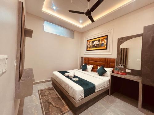 - une chambre avec un lit et un ventilateur de plafond dans l'établissement The Solitaire Express Vrindavan, à Vrindavan