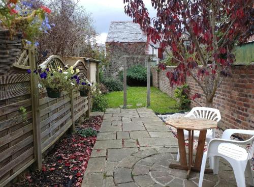a garden with a table and chairs and a fence at Ty Newydd Gwyn - G/F Room in Denbigh