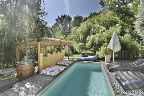 une piscine avec un kiosque et une piscine dans l'établissement Villa du bois - Spa & piscine, à Lignan-de-Bordeaux