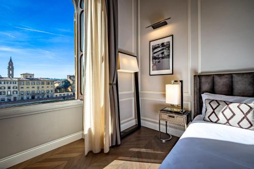 a bedroom with a bed and a large window at Il Rivalta - Place of Charme in Florence