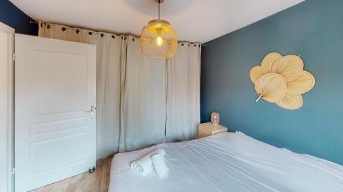 - une chambre avec un lit blanc et un mur bleu dans l'établissement Appartement clin d oeil au centre d Obernai, à Obernai