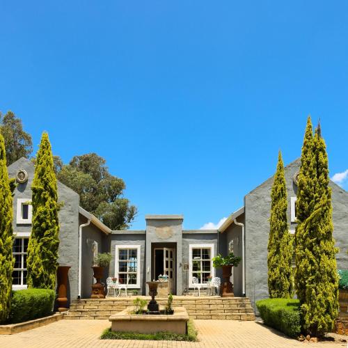 a house with trees in front of it at Country Retreat in Magaliesburg in Magaliesburg