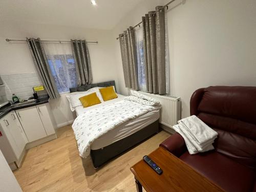 a small bedroom with a bed and a couch at 2nd Studio Flat With Great Views in Keedonwood Road With Private Kitchenette and shared bathroom in Bromley