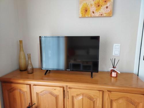 a flat screen tv sitting on top of a wooden cabinet at Montaña & Mar in Miami Platja