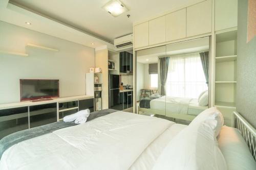 a bedroom with a large white bed and a window at Stylish & Cozy Studio in central Jakarta, SCBD in Jakarta