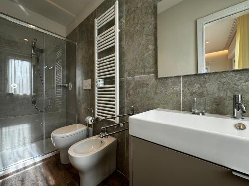 a bathroom with a sink and a toilet and a mirror at SKYLINE Siena in Siena
