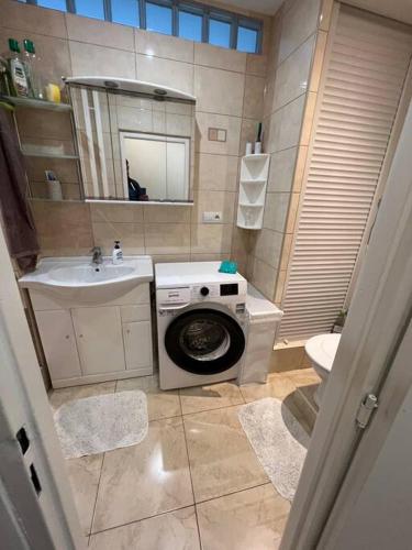 a bathroom with a washing machine and a sink at Tichá lokalita, MHD do 5 minút, len 2 km od centra in Košice