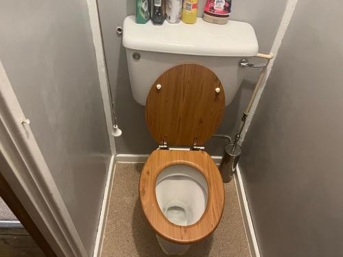 ein Badezimmer mit einem WC und einem Holzsitz in der Unterkunft Queenomega’s home stay in London