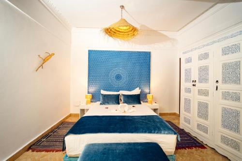 a bedroom with a bed and a blue wall at Riad Oscaroi in Marrakesh