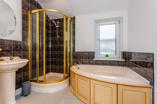 a bathroom with a tub and a sink and a mirror at Wonderful House near the Castle in Haltwhistle