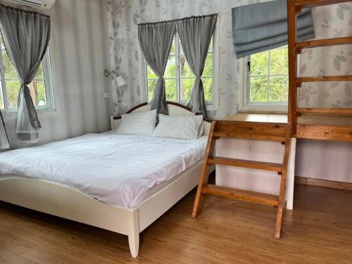 een slaapkamer met een stapelbed en een ladder bij The Open Hills in Chongsadao