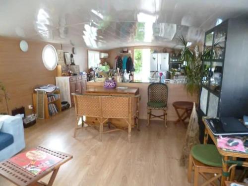 un salon avec une table et des chaises dans l'établissement House boat AJA, à Vigneux-sur-Seine