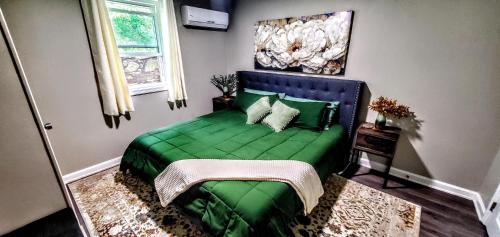 a bedroom with a green bed with a painting on the wall at Cozy Nashville Duplex Unit B in Nashville